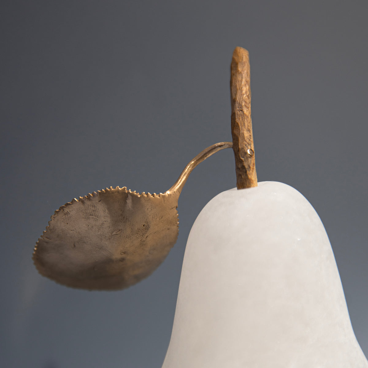 Pear with a gold leaf on a gray background